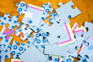 Close-up of colorful jigsaw puzzles for children with children drawings on the floor - 394602861
