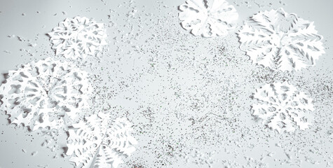 Winter light abstract background with paper snowflakes and sparkles copy space.