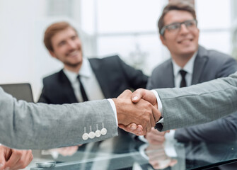 handshake of business people on a blurred office background.