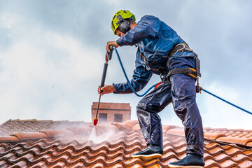 Fototapeta worker washing the roof with pressurized water obraz