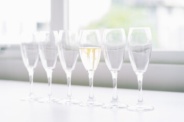 six glasses of wine on the table and only 1 with wine, concept of difference