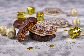 German round gingerbread called 'Lebkuchen' with white and chocolate glazing and missing bite surrounded by seasonal Christmas decoration
