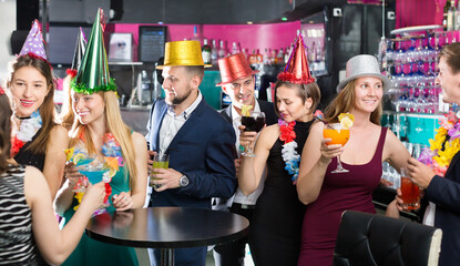 Young friends dancing on a birthday party with cocktails