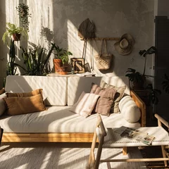 Fotobehang Boho Warm boho style modern home interior design. Sofa, pillows, home plants, carpet and decorations against concrete wall.  © Floral Deco