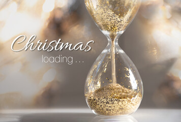 Sandglass with trickling sand and golden glitter surrounded by sparkling lights and text 
