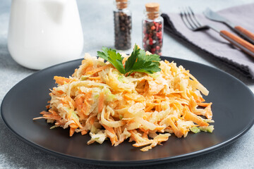 Salad of fresh grated carrots and green radish with sauce.