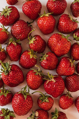 Closeup of raw fresh strawberries pattern on pink background.