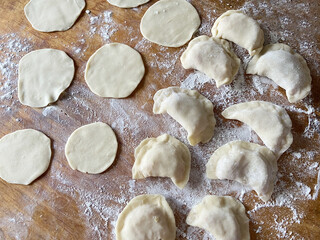 Raw dumpling with potatoes. Preparation dumplings on a wooden board. sculpting pies