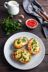 Baked potatoes in the peel stuffed with cheese with garlic and herbs.