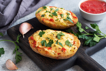 Baked potatoes in the peel stuffed with cheese with garlic and herbs.
