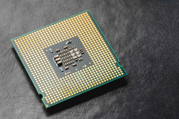 The microprocessor processor of the CPU of a computer or laptop lies on a dark matte surface....