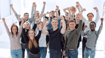 large group of happy young people with hands up