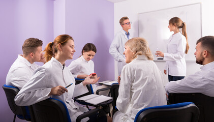 Group of happy medical students with teacher in break between lessons indoors