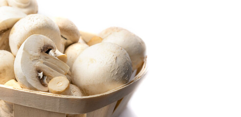 Fresh champignons in a basket isolated on white background.