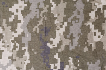 Slightly crumpled fabric with digital camouflage pattern close-up, background