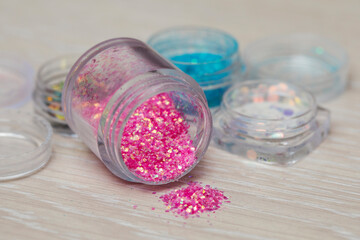 Obraz na płótnie Canvas Beautiful multi-colored glitter in a jar in a nail salon to create a New Year's nail design.