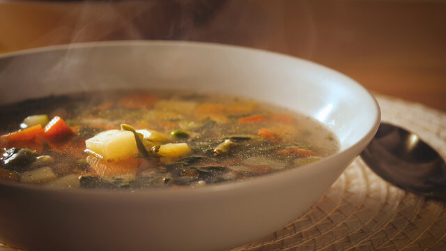 Minestrone soup dish is on table. Vegetarian healthy meal for dinner. Ready vegetable meal for lunch, hot and cozy soup for dinner at home. tablespoon