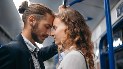 man and a woman in love standing in a subway car.