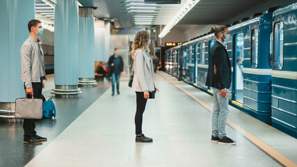 Obraz premium people in protective masks standing on the subway platform .