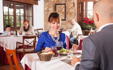 Fototapeta na wymiar Adult couple at restaurant having dinner and talking