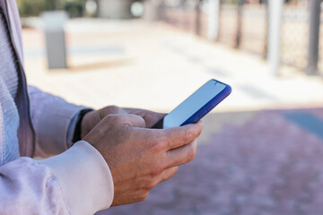 hands of an unrecognizable man sending text message