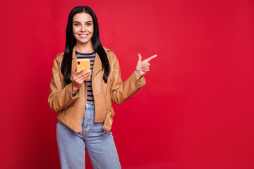 Portrait of nice positive person indicate finger empty space promotion isolated on red color background