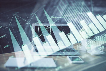 Stock market graph on background with desk and personal computer. Double exposure. Concept of financial analysis.