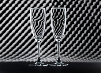 Two empty wine glasses on an abstract background. Black and white.