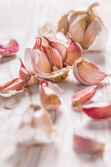 Garlic bulb and garlic cloves on white wooden background