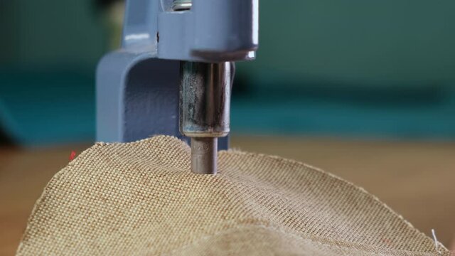 Garment Making Workshop. Factory. Riveting Machine. Piece of Cloth is Fastened under Small Press. Metal Rivet Installed in Material. Button on Jacket. Clip. Metal Product in Clothes. Manual labor