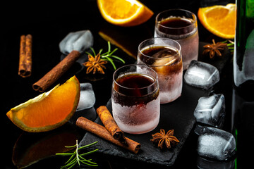 alcoholic drink and orange in ice glasses. Alcoholic booze cocktail. german digestif made with 56 herbs and spices
