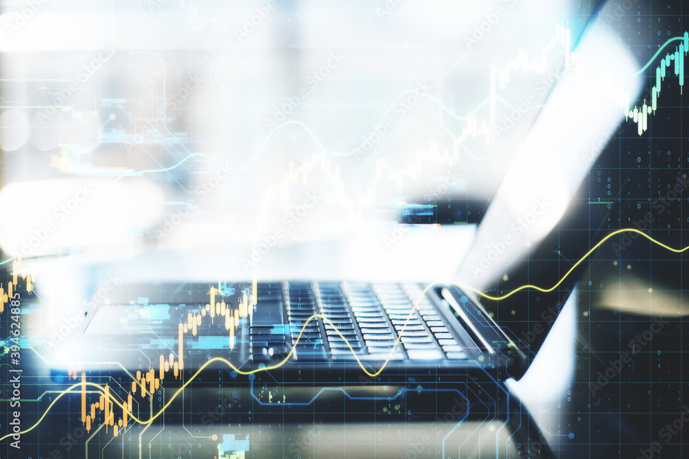 Poster Laptop computer on desktop with stock charts interface.