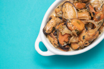 Mussels without shell slices in white ceramic bowl. Seafood concept. Selective focus. Space for text