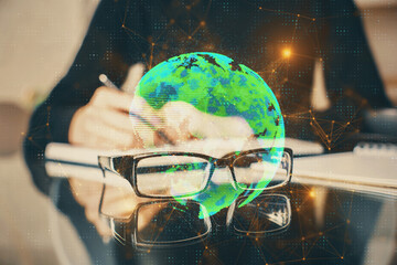 Social network theme hologram over hands taking notes background. Concept of global international people connect. Double exposure