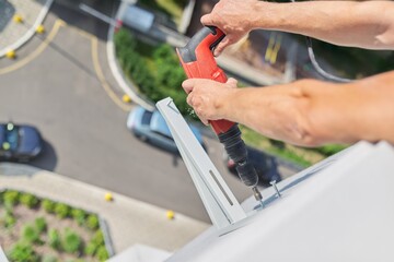 Installing the outdoor unit of the air conditioner, using drill fixing the unit holders