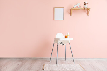 Modern interior with baby highchair on color background