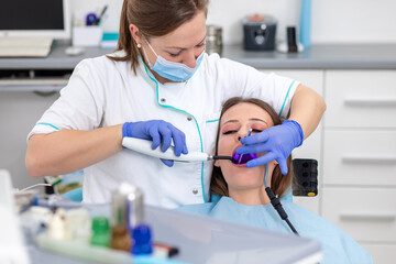Young woman having teeth examined by female dentist in dental office.