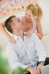 Frau massiert ihrem Mann den Nacken