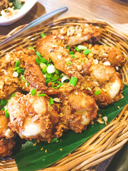 fried chicken with fried garlic and spring onions on topped served in a basket