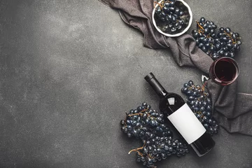 Wandaufkleber Tasty red wine with fresh grapes on dark background © Pixel-Shot