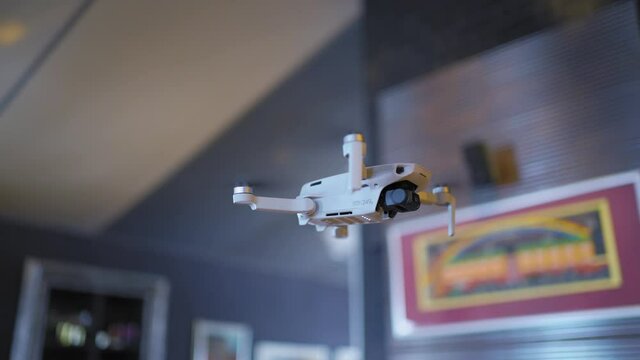 A small drone weighing 249 grams close-up on a blurred background at home, the drone camera shoots in 4 K