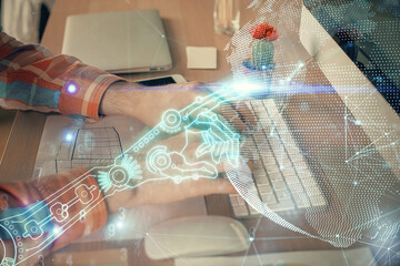 Technology theme hologram with man working on computer on background. High tech concept. Double exposure.