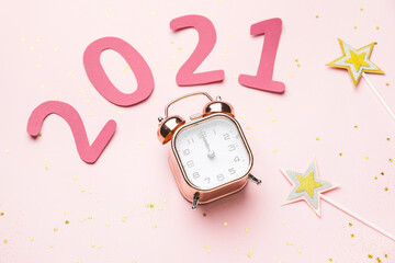 New Year composition with alarm clock and figure 2021 on color background