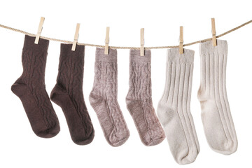 Warm socks hanging on clothes line against white background