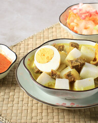 Indonesian Traditional Cuisine: Lontong Kari Sapi, Rice Cake or Ketupat Served with Beef Curry Soup Made from Beef Stock and Light Coconut Milk, Various Spice and Indonesian Herbs