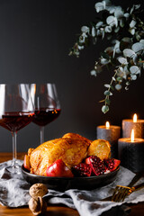 Whole roast chicken with pomegranate, apple and red wine on a festive table. Christmas or New Year...
