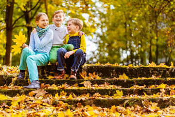 Two cute adorable playful caucasian siblings boy girl child enjoy havefun on playground at backyard or city park outdoors. Little toddler brother and sister portrait hugging and smiling. Family care