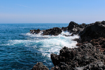 Fototapeta na wymiar Blue ocean waves with rocks on the beach