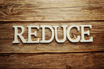 Reduce word alphabet letters on wooden background