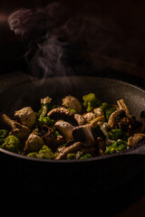 White champignons, onion and green broccoli fry on pan or wok. Hot delicious vegetarian dinner.